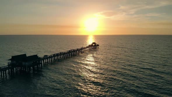 Flying Along a Wooden Long Pier at Sunset Time.