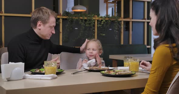 Charming Daughter Cleaning Hands After Meal in Restaurant