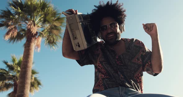 Young african american man listening music with vintage boombox stereo outdoor