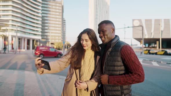 Delighted Multiethnic Couple Taking Self Shot in City