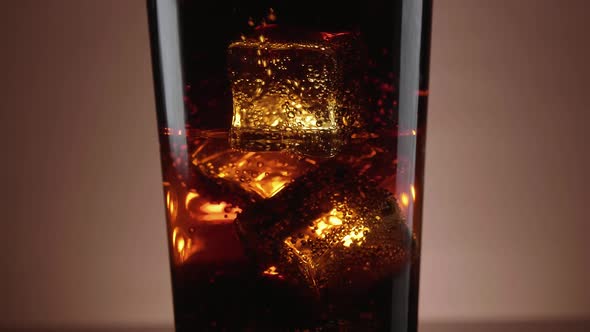 A Glass of Refreshing Cola with Floating Ice Cubes