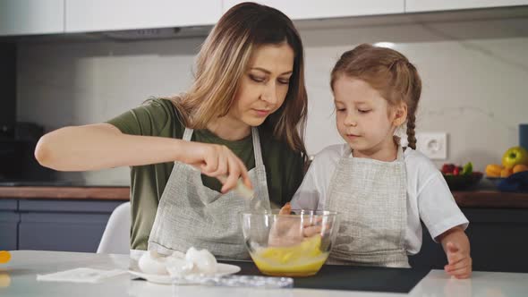 Mother Shows Her Little Daughter in Kitchen