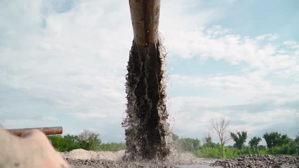 Wastewater from Large Rust Pipe Merge into Environment on the background of the Forest