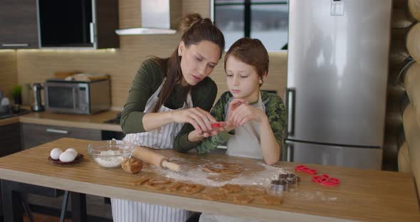 Young Family Mother and Son Making Homemade Cookies at Kitchen Table Working with Dough Smiling