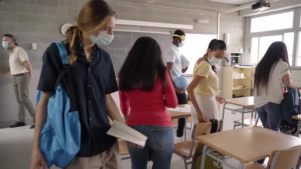 Teacher and High School Students Enter the Classroom Wearing Protective Masks