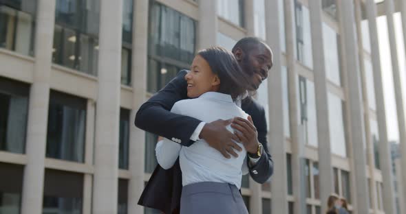 Low Angle View of Cheerful African Colleagues Triumphing and Hugging on Street