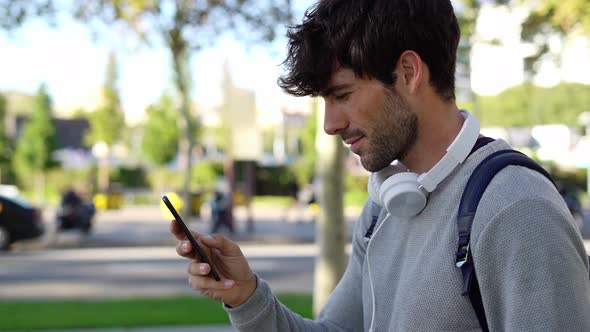 Man with backpack and smartphone in the city