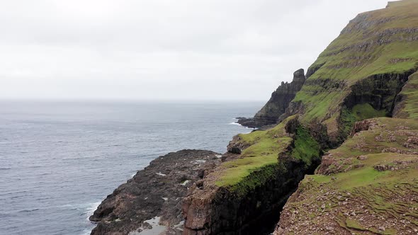 Aerial Back View of Huge Cliffs in Faroe Islands Green Rocky Mountainpowerful Ocean Wavesin a Cloudy