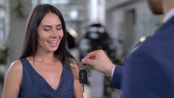 Portrait of Cheerful Female Taking Key To New Car