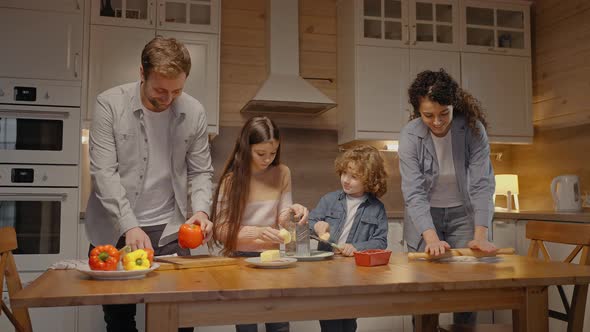 Parents Cooking Dinner Together at Home with Kids Helping Them