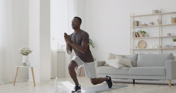 Athletic Black Man Doing Forward Lunge Exercises at Home, Training Legs and Hip Muscles