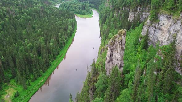 Landscape of Rocky Pillar Standing By Calm River with Upright Cliff Surrounded with Horizonless