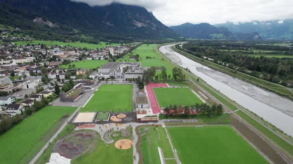 Liechtenstein with Houses on Green Fields in Alps Mountain Valley Aerial View