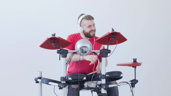 Hobby and Music Concept Young Man Having Fun Playing Electronic Drum Kit At Home