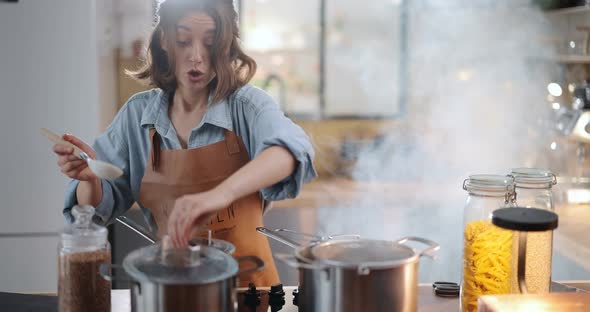 Housewife Hurries on the Kitchen with a Smoke From Burning Food