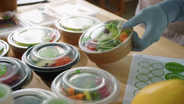 Worker Applying Gluten Free Sticker on Food Container