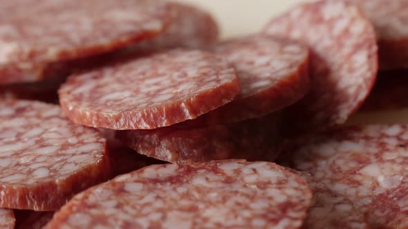 Salami smaller pieces on table 4K 2160p 30fps UltraHD  tilting  footage - Food background of cured s