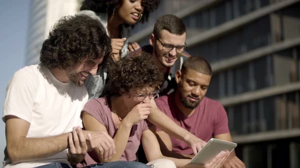 Happy Friends Looking at Tablet and Laughing.