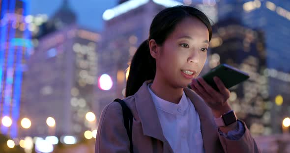 Business woman work on smart phone in Hong Kong at night