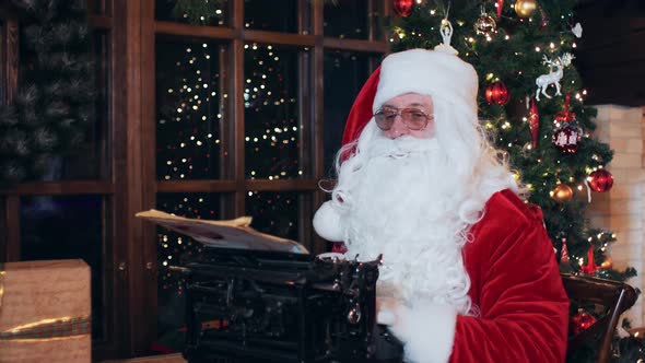Santa Claus writes a letter at a typewriter