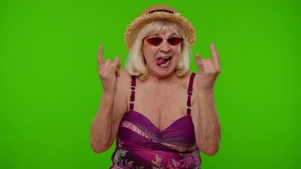 Senior Woman Tourist in Swimsuit Dancing Celebrating Showing Tongue Rock and Roll Hand Gesture