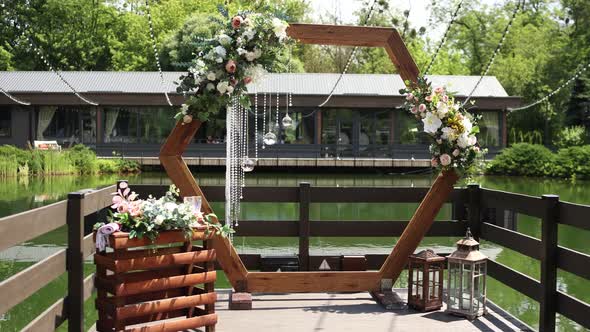 wooden wedding arch for the ceremony in the park near the water