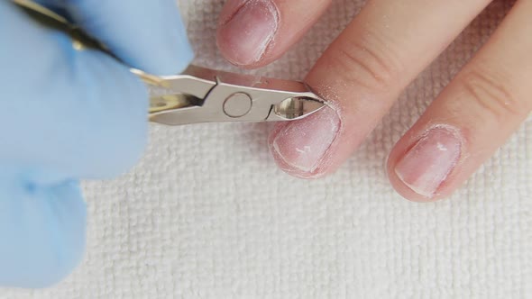 Young Woman Removes Cuticle From Nails Using Pedicure Manicure Tool