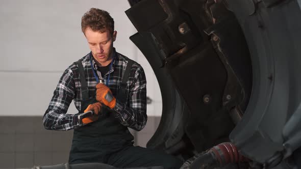 Young Mechanic Repairing a Truck in Auto Repair Shop