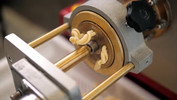 Tortiglioni Cazarece Spaghetti Pasta Falling From a Spout As They Travel Along the Production Line