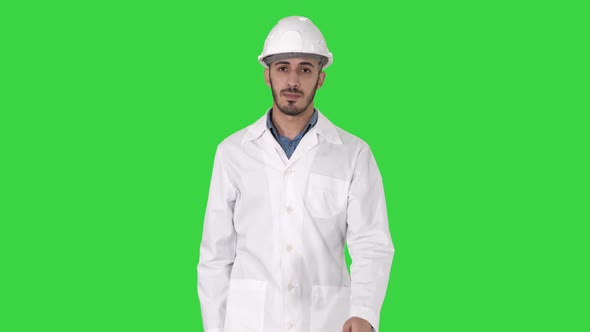 Arab Engineer in Helmet and White Robe Walking Forward on a Green Screen, Chroma Key.