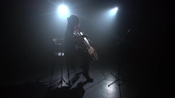 Musician Plays the Cello in Dark Studio