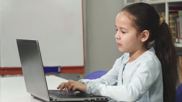 Happy Beautiful Asian Little Girl Smiling While Using Laptop