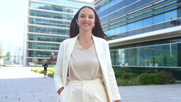 Cheerful Young Businesswoman in Smart Casual Wear Walking Outdoors