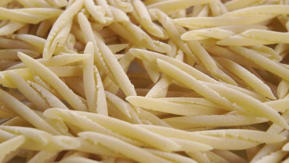 Traditional Italian trofie pasta close up. Macro. Rotation. Uncooked dry macaroni