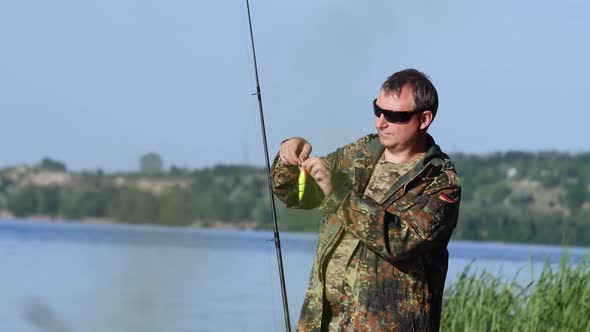 Man Clings a Bait To a Fishing Rod, He Wants To Catch Fish