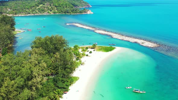 small sandbar in the turquoise waters of the Thailand coast. Lush jungle, sand beach and peaceful se