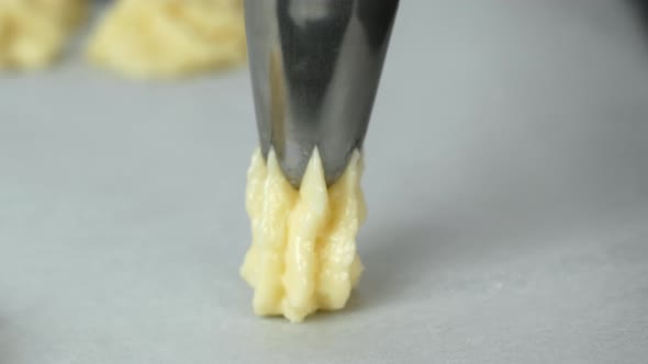 The pastry chef makes beautiful cookies with a cream sleeve, laying them out on a baking sheet