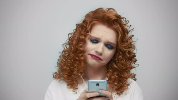 Woman Typing on Smartphone at Grey Background. Girl Using Mobile Phone