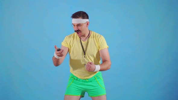 Funny Joyful Male Trainer From the 80's with a Mustache and Glasses with a Stopwatch