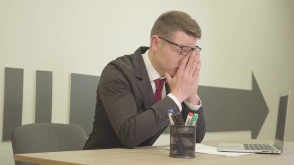 Portrait Young Nervous Stressed Busy Man in Formal Wear and Glasses Sitting in the Office in Front