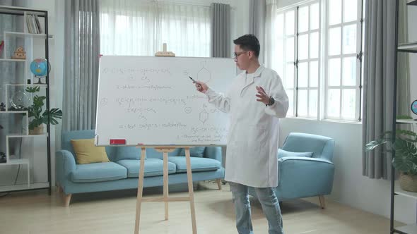 Asian Male Teacher With Glasses Teaching Chemist At Home