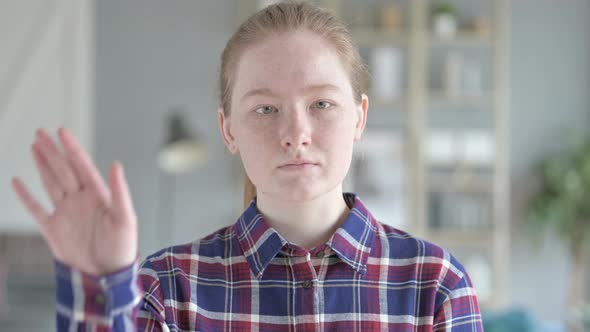 Close Up of Young Woman Showing Stop Sign With Hand