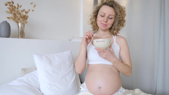 Smiling Pregnant Woman Having Breakfast In Bed