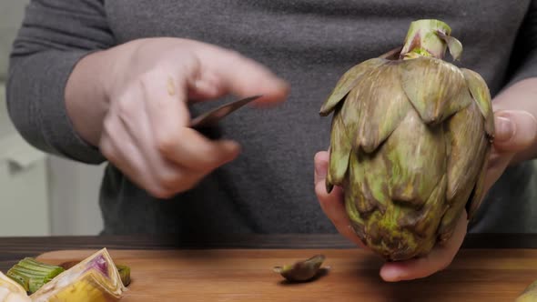 Woman Cleaning Artichokes with Knife