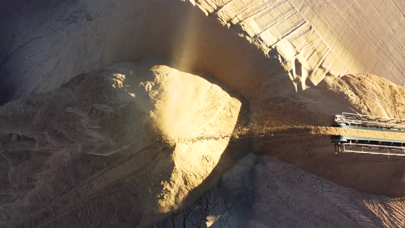 A conveyor in salt pits, extracts potash salts, pours sand into a heap.