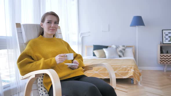 Relaxing Woman Drinking Coffee while Sitting on Casual Chair