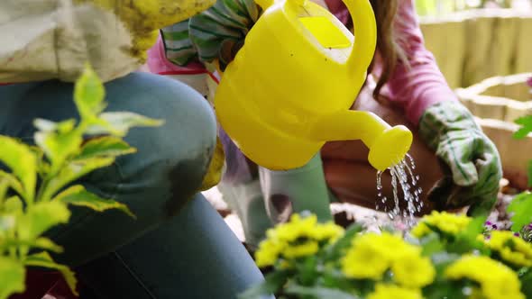 Couple watering flower in garden
