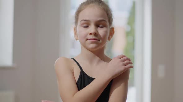 Portrait of Teenage Confident Gymnast Hugging Self in Slow Motion Looking at Camera Smiling