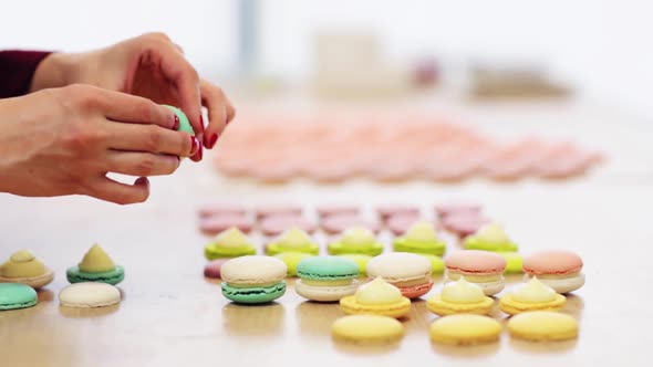 Chef Sandwiching Macarons Shells with Cream 