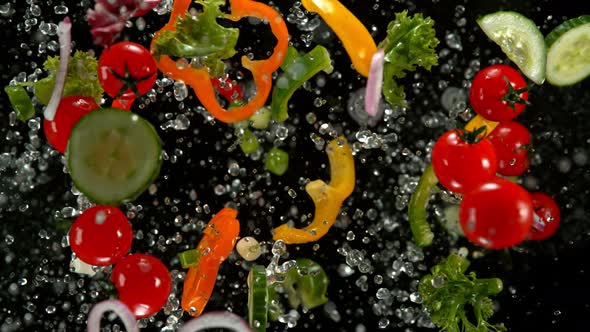 Super Slow Motion Shot of Flying Cuts of Colorful Vegetables and Water Drops on Black at 1000Fps